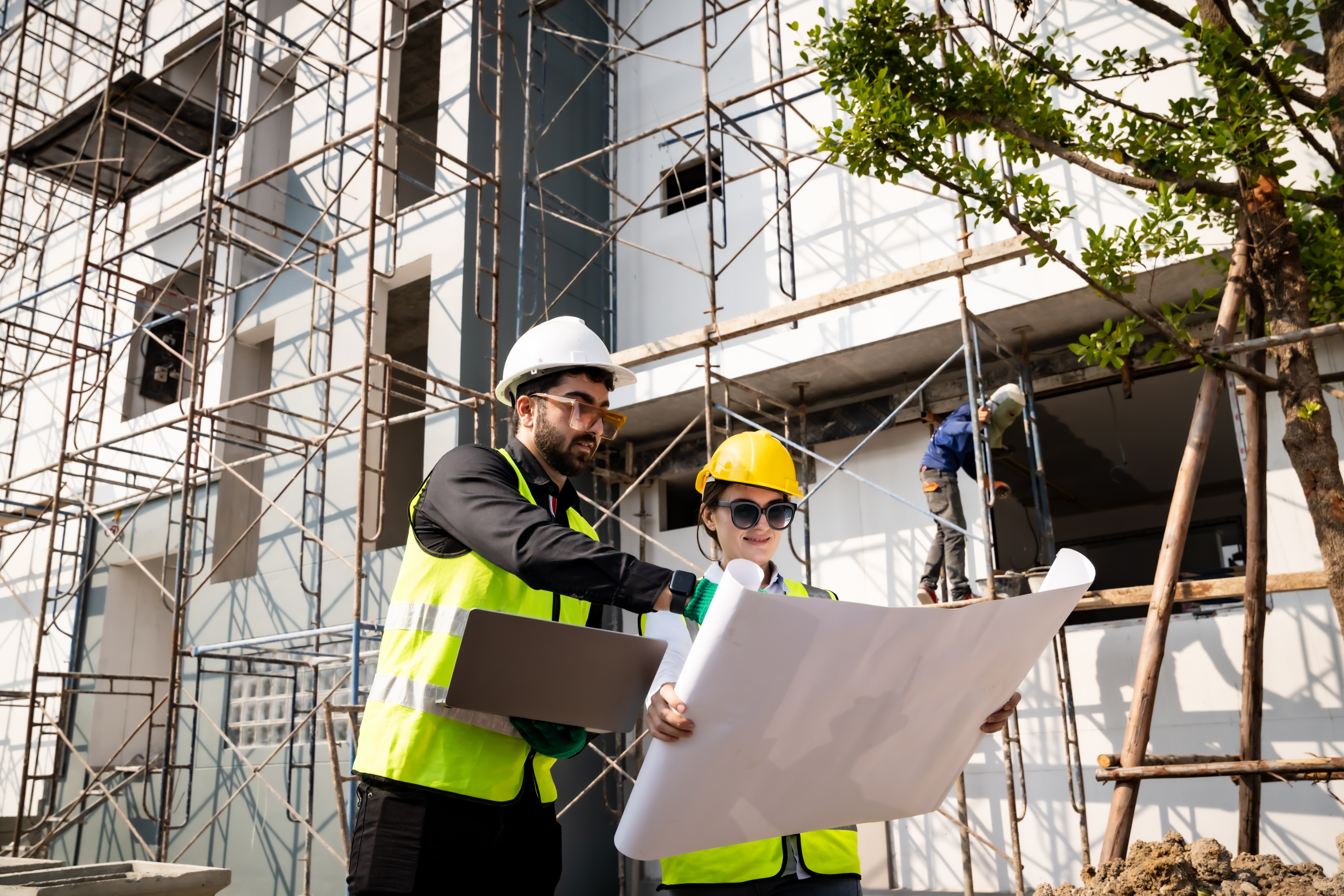 Two workers reviewing blueprints